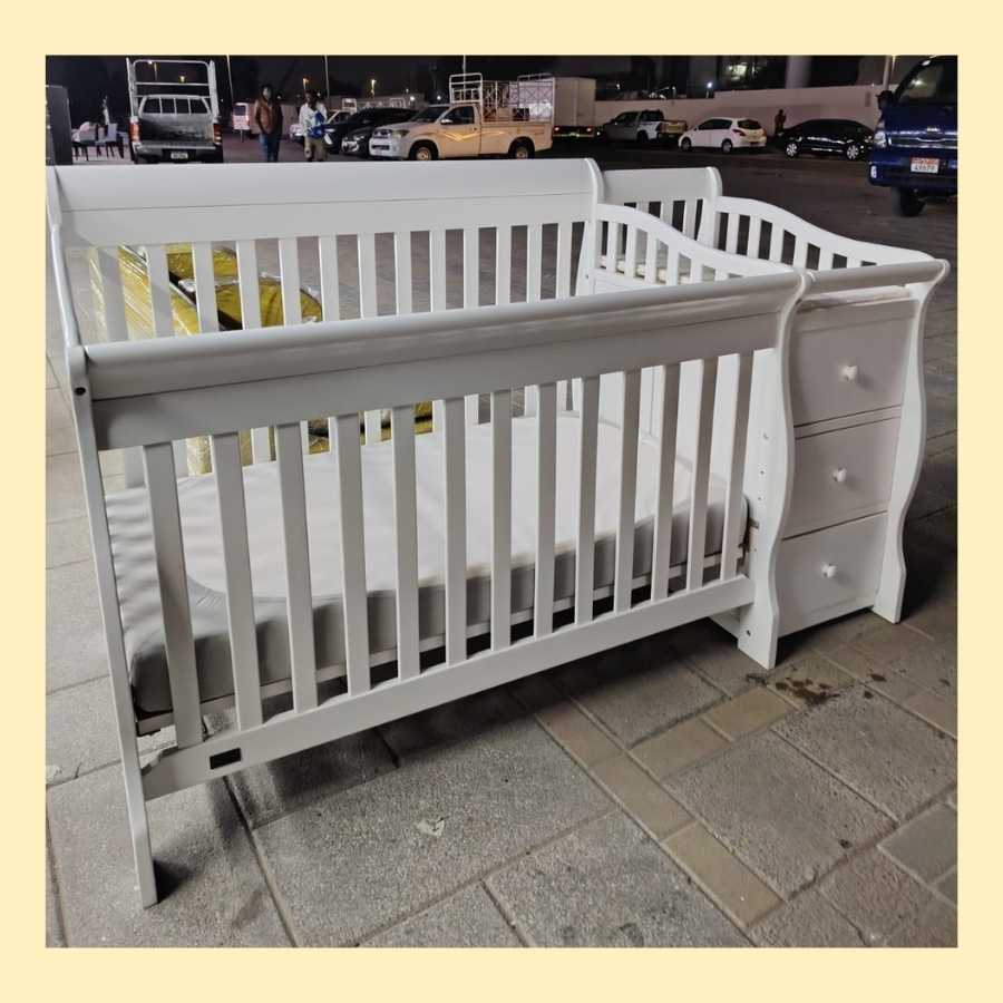Wooden convertible baby cot Abu Dhabi with built-in storage drawers for newborns and toddlers