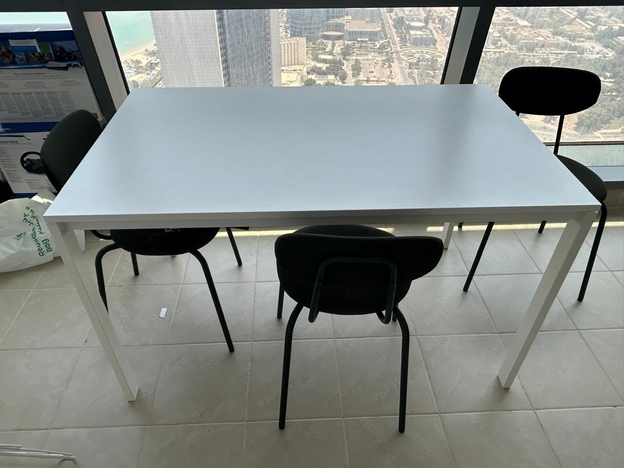 Modern used dining table with four chairs available for sale in Abu Dhabi.