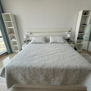 Modern white used bed with mattress and matching side tables available for sale in Abu Dhabi.