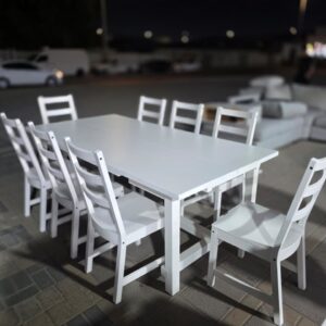 Modern white wooden 8-seater used dining table set in Abu Dhabi with ladder back chairs displayed at Fairy of Fortune store
