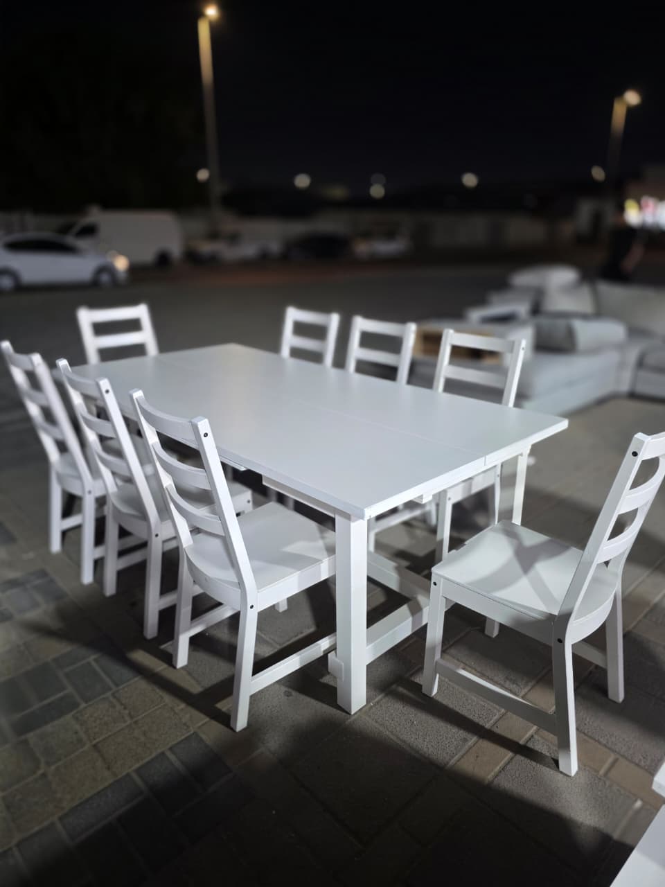 Modern white wooden 8-seater used dining table set in Abu Dhabi with ladder back chairs displayed at Fairy of Fortune store